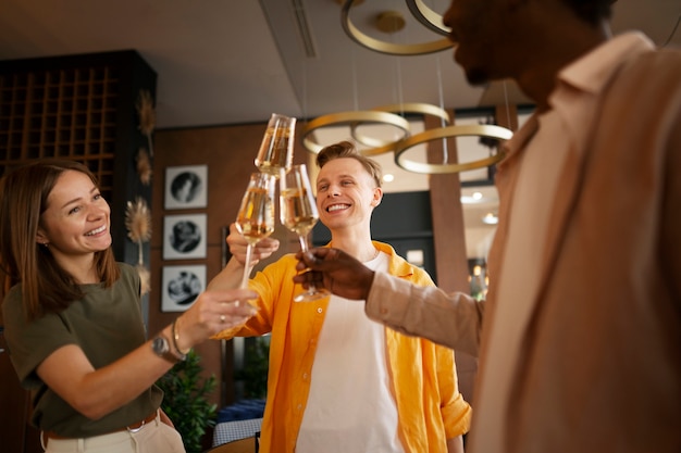 Een groep vrienden die met wijnglazen bij een restaurant juichen