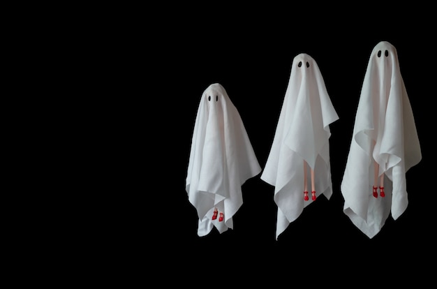 Een groep vrouwelijk kostuum van het spook witte blad dat in de lucht met zwarte achtergrond vliegt. minimale enge halloween.