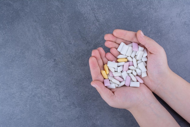 Een handvol kauwgomtabletten op een marmeren oppervlak