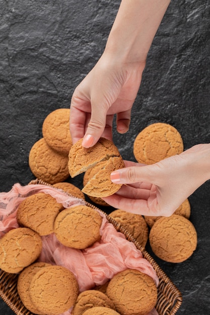 Een havermoutkoekje in de hand in twee stukken snijden.