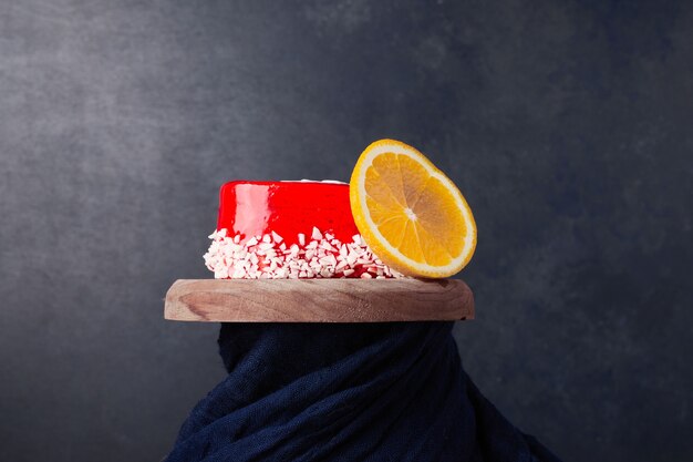 Een hele cake met rode gelei en een schijfje sinaasappel