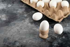 Gratis foto een houten eierdopje met gekookt kippenei.