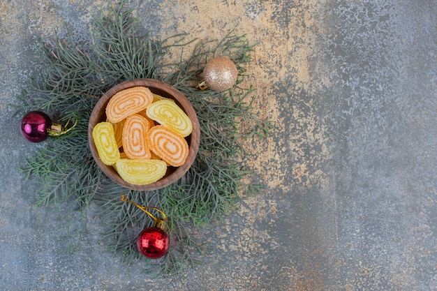 Gratis foto een houten kom vol met fruit gelei oranje en gele snoepjes. hoge kwaliteit foto