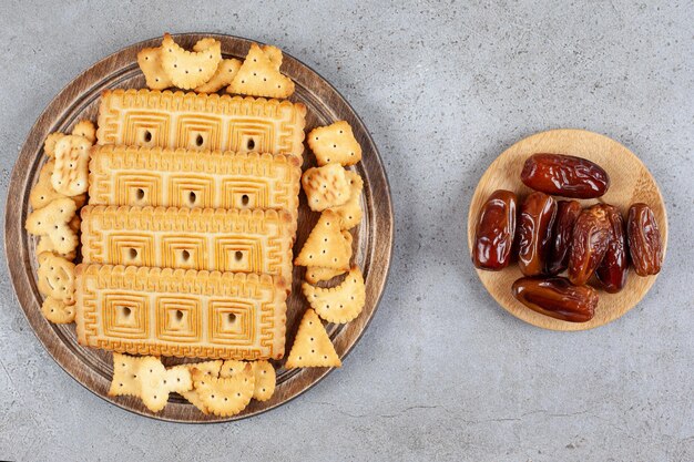 Een houten plank vol koekjes op een marmeren ondergrond