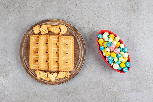 Een houten plank vol koekjes op marmeren oppervlak.