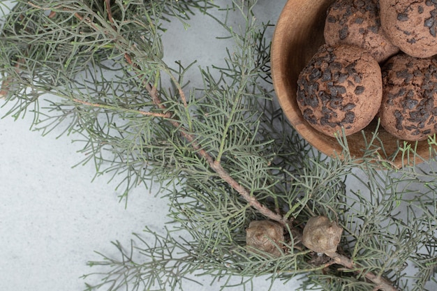 Een houten schaal met chocoladekoekjes met kerstboom