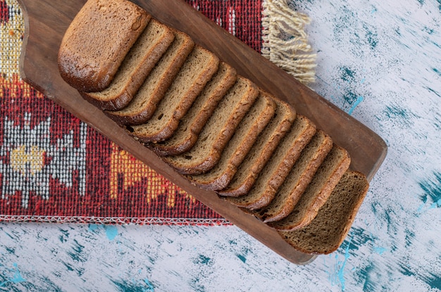 Gratis foto een houten snijplank met sneetjes brood.