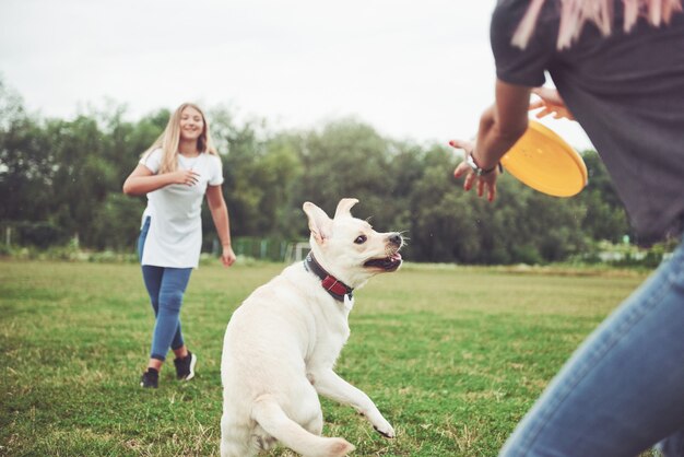 Een jong lachend meisje met een gelukkige blije uitdrukking speelt met haar geliefde hond.