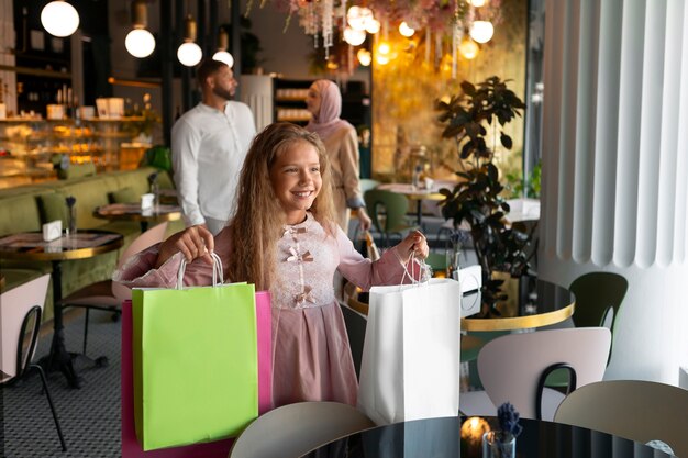 Een jong meisje gaat shoppen met haar ouders