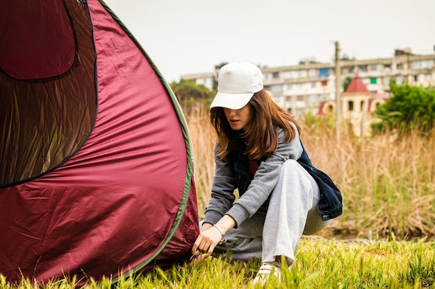 Een jonge dame die haar tent opzet in het bos