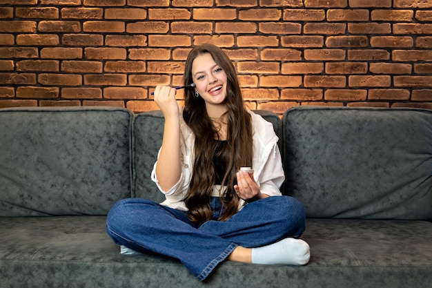 Een jonge glimlachende vrouw die make-up maakt