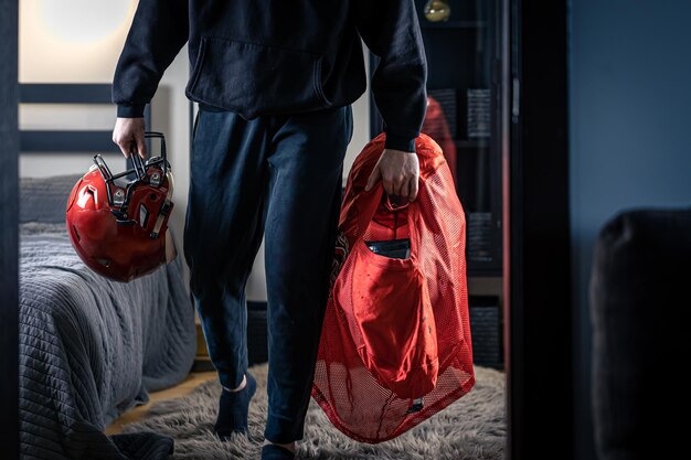 Een jonge man met een voetbalhelm in zijn kamer