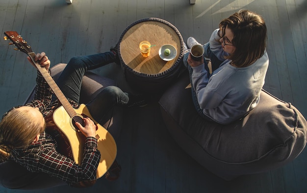 Gratis foto een jonge man speelt gitaar voor een bovenaanzicht van een meisje