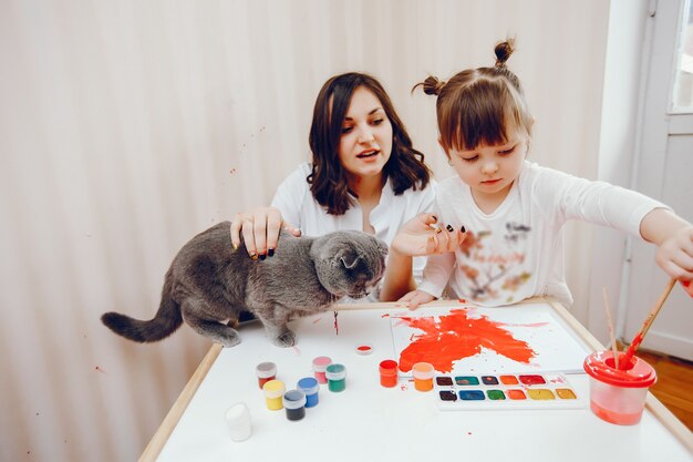 Een jonge moeder schildert samen met haar dochtertje op papier