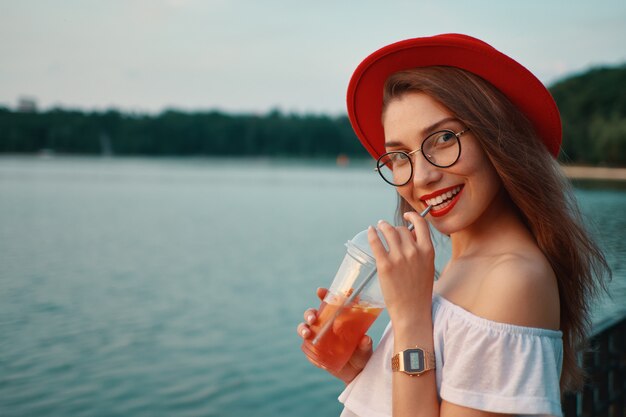 Een jonge stijlvolle vrouw met een verfrissend drankje