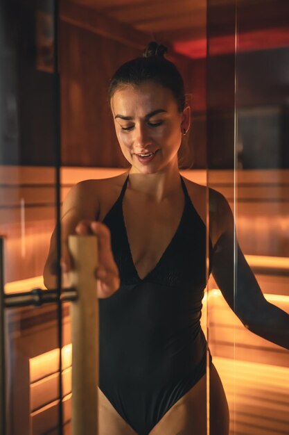 Een jonge vrouw die alleen in de sauna rust