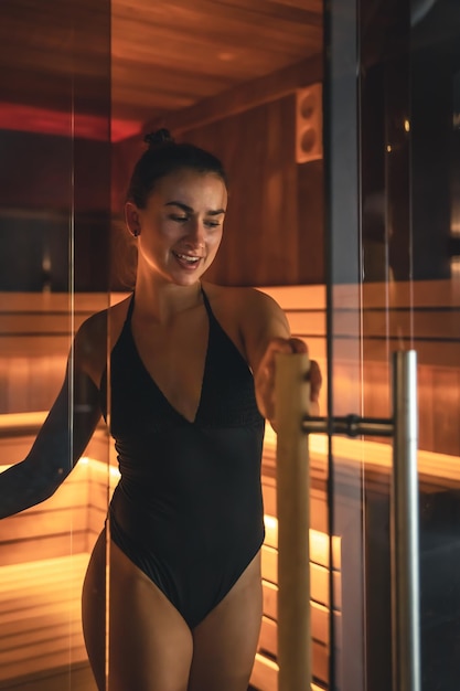 Gratis foto een jonge vrouw die alleen in de sauna rust