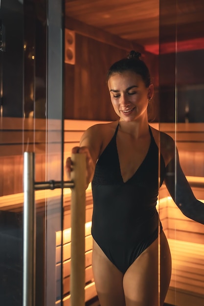 Een jonge vrouw die alleen in de sauna rust