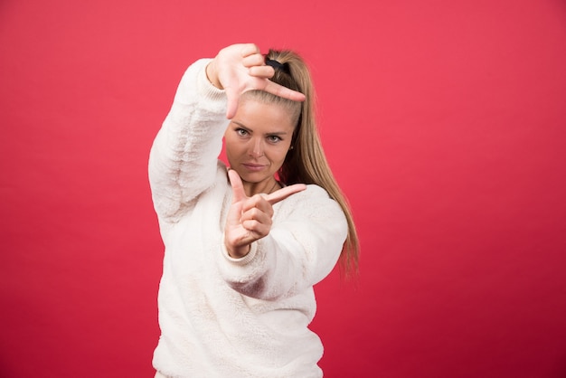 Een jonge vrouw die een sweater draagt die iets kleins met handen toont