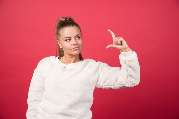 Een jonge vrouw die een sweater draagt die iets kleins met handen toont