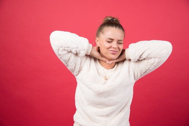 Een jonge vrouw die keel vasthoudt en aan pijn lijdt