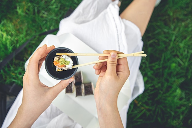 Een jonge vrouw die sushi eet in de close-up van het makibroodje van de natuur