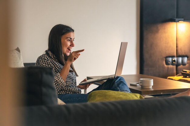 Een jonge vrouw die thuis op een laptop werkt