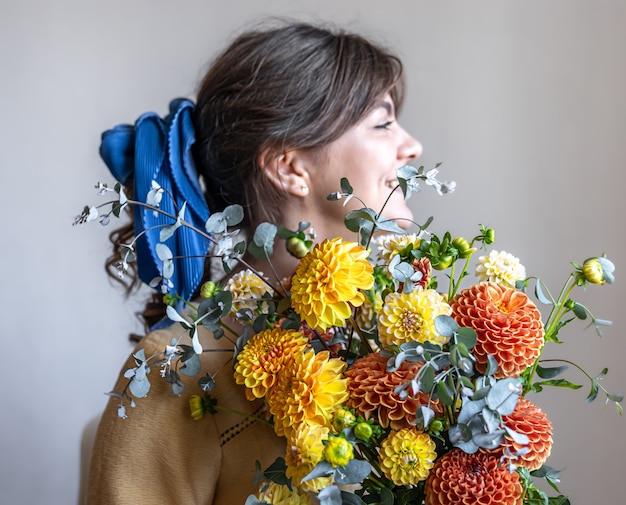 Gratis foto een jonge vrouw houdt een boeket chrysanten vast