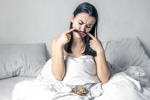 Een jonge vrouw in wit bed met ontbijtgranen en melk