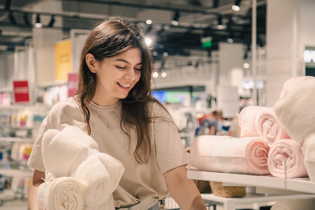 Een jonge vrouw kiest dekens voor een interieur in een bouwmarkt