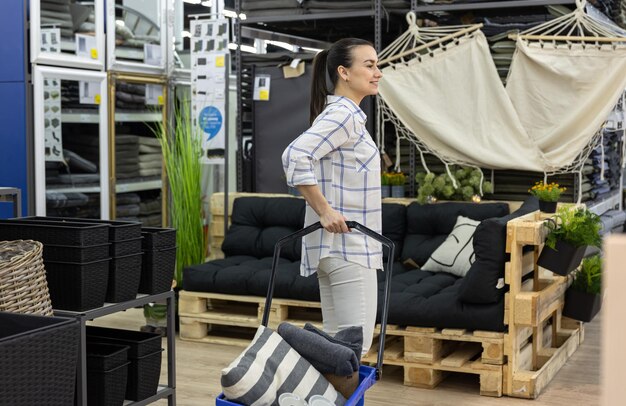 Een jonge vrouw kiest goederen voor een interieur in een winkel