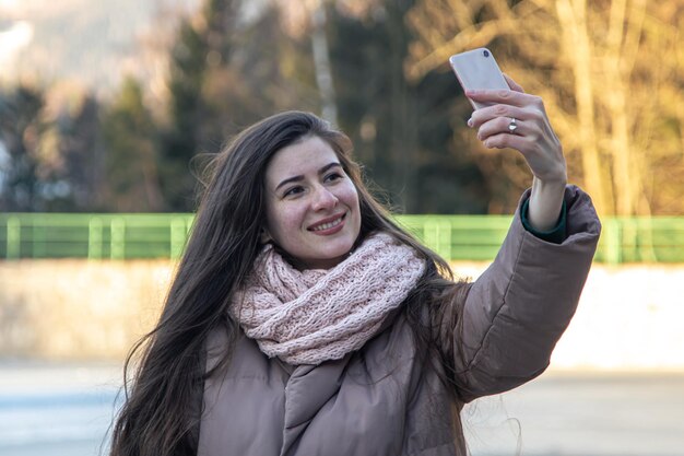 Een jonge vrouw maakt een selfie tijdens een wandeling in de bergen