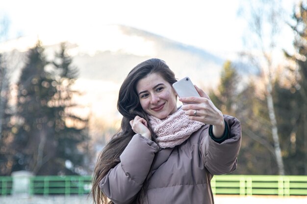 Een jonge vrouw maakt een selfie tijdens een wandeling in de bergen