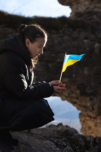 Gratis foto een jonge vrouw met de vlag van oekraïne in haar handen