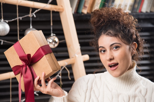 Een jonge vrouw met een geschenkdoos met strik