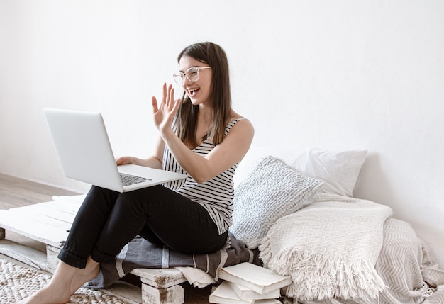 Een jonge vrouw werkt thuis op afstand op een computer. freelancer en werk op internet.
