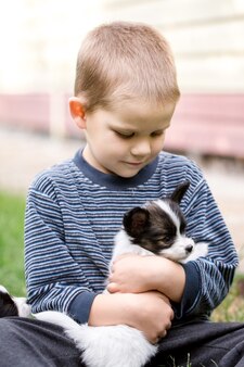 Een jongen met een huisdier in de tuin