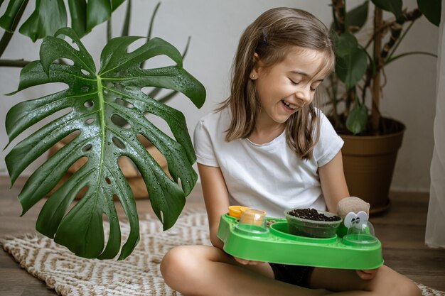 Een klein meisje met een babypakket om zelf een plant te kweken.