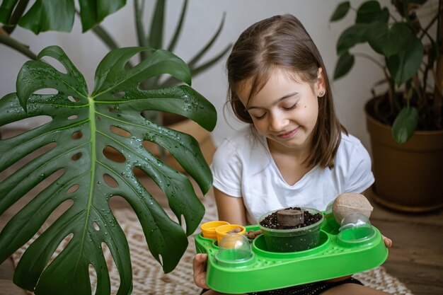 Een klein meisje met een babypakket om zelf een plant te kweken.