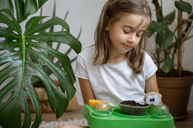 Een klein meisje met een babypakket om zelf een plant te kweken.