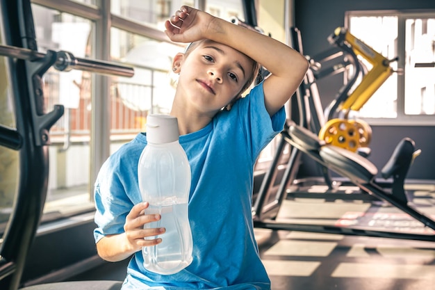 Gratis foto een klein meisje met een flesje water na een training