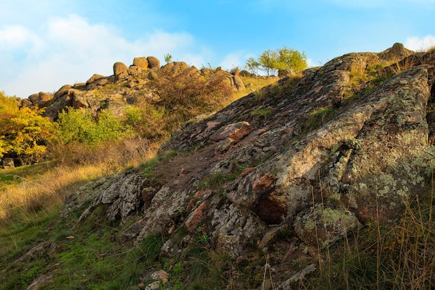 Een kleine stapel stenen in een groen-geel veld tegen de achtergrond van een lucht in oekraïne