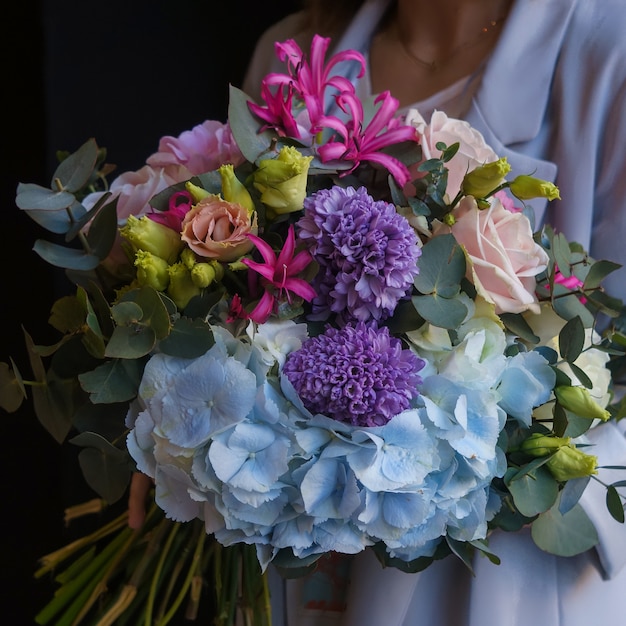 Een kleurrijk boeket anjers, rozen, windbloemen en flossbloemen