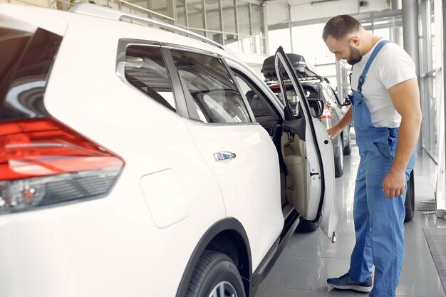Een knappe man in een blauw uniform controleert de auto.