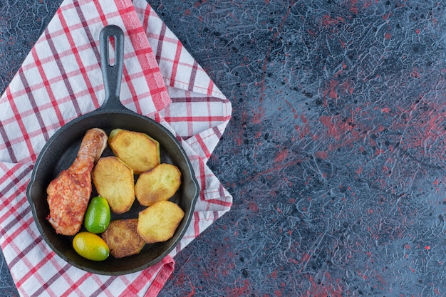 Een koekenpan met kippenvlees en groenten