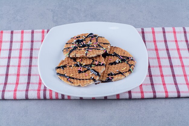 Een koekenpan van ronde rossige wafel met hagelslag en room