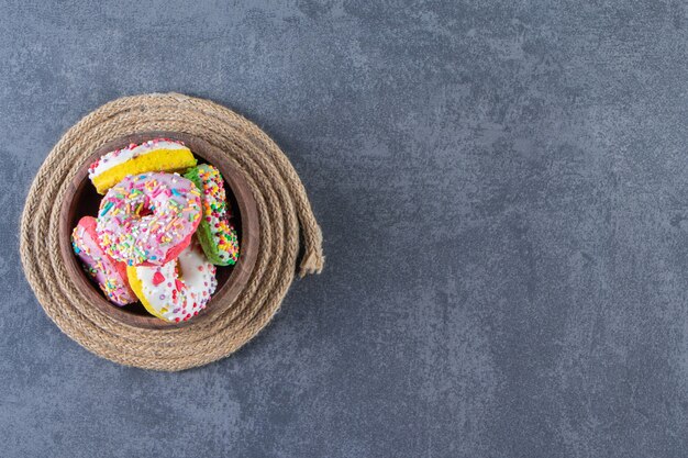 Een kom donuts op een onderzetter, op de marmeren achtergrond.