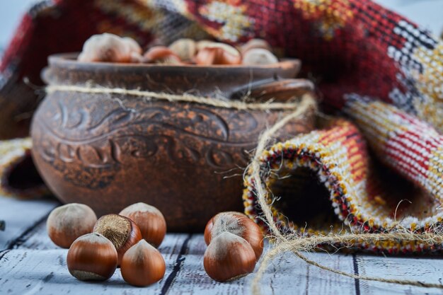 Een kom hazelnoten op blauwe houten tafel met gebeeldhouwd tapijt