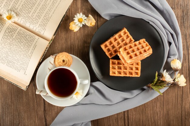 Een kop voor thee en wafels in een schotel