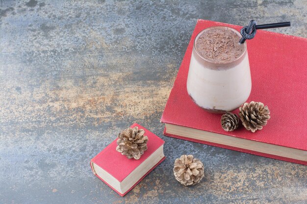 Een kopje koffie met boek en dennenappels op marmeren achtergrond. Hoge kwaliteit foto